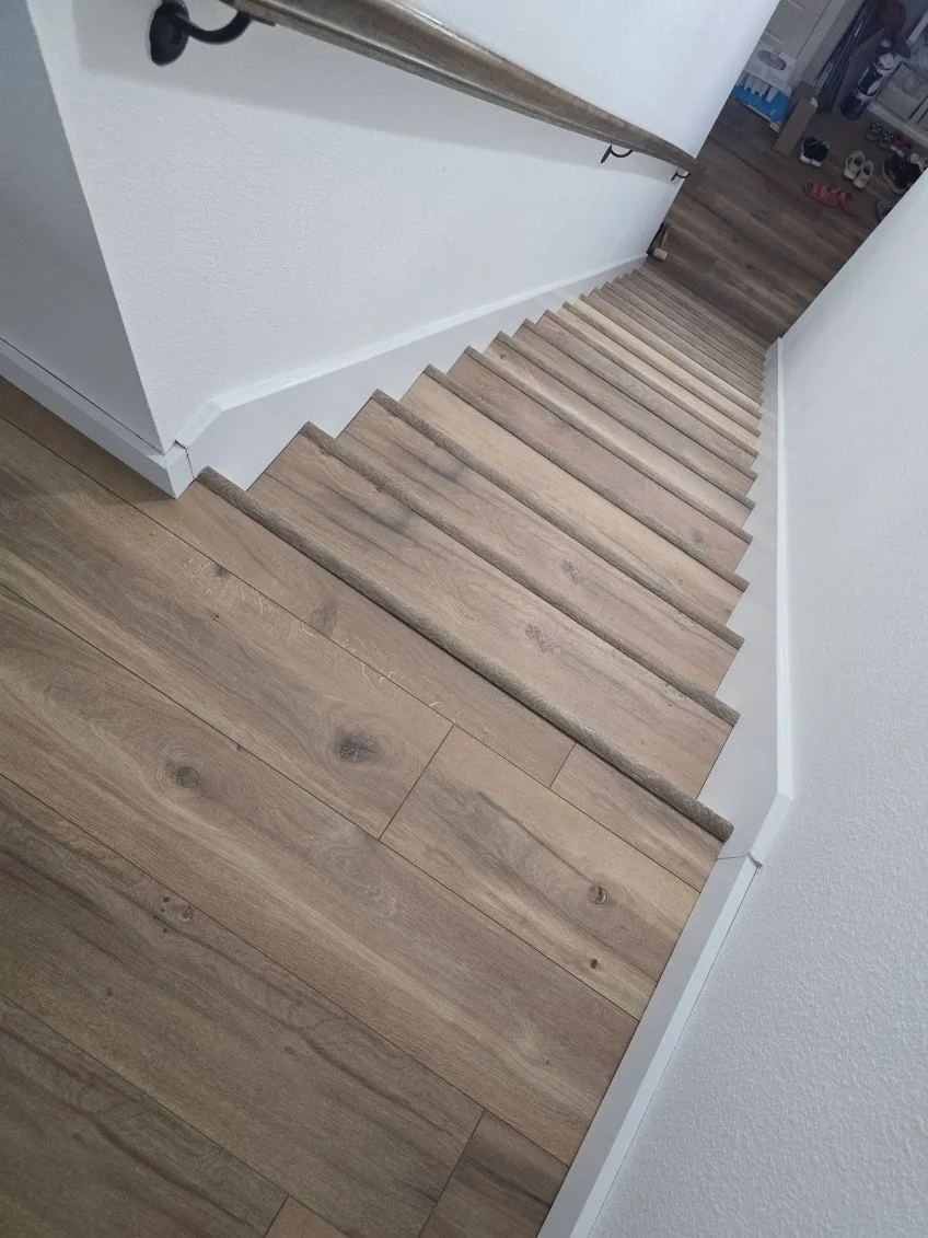 Laminate staircase with wood-grain finish and white walls, newly installed