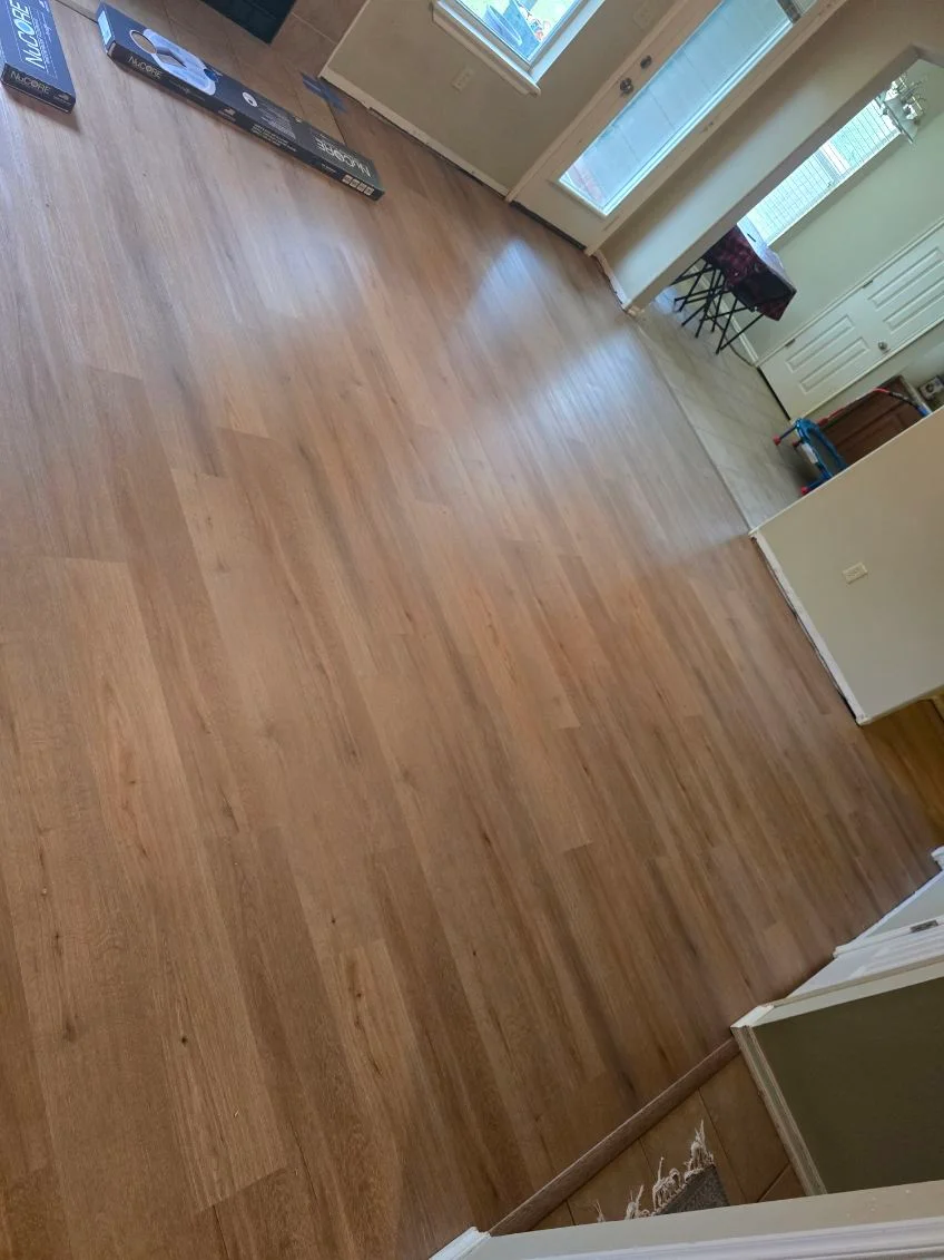 Newly installed warm-toned laminate flooring in residential room with skylights