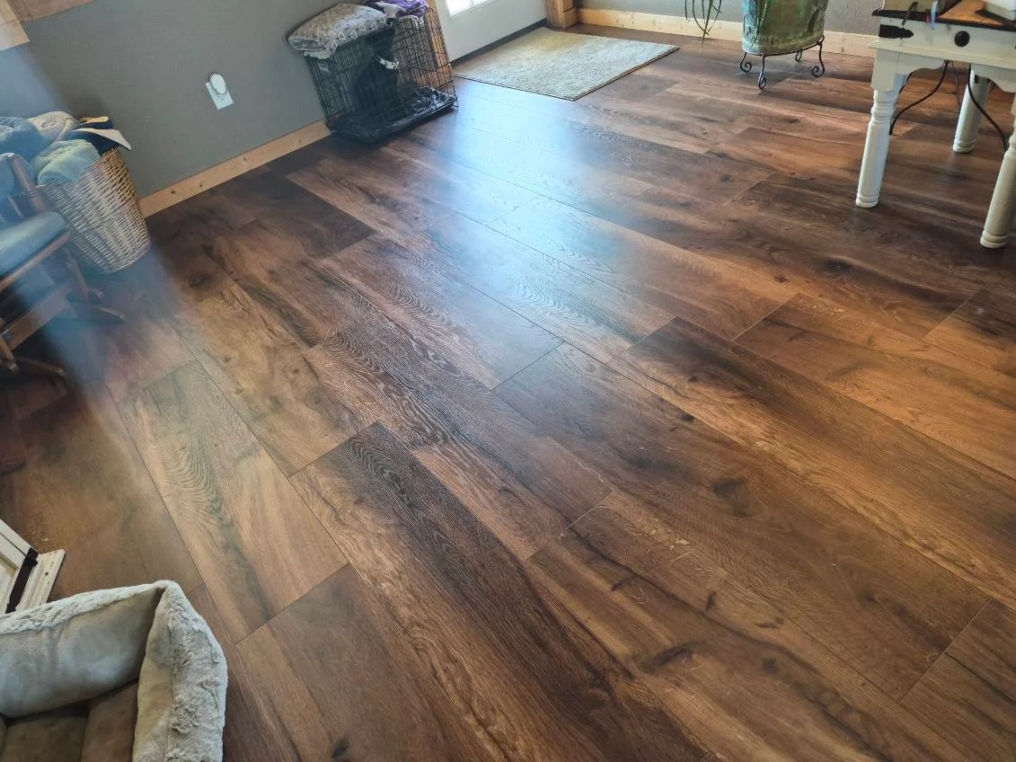 Newly installed luxury vinyl plank flooring with warm wood-grain finish in open living room
