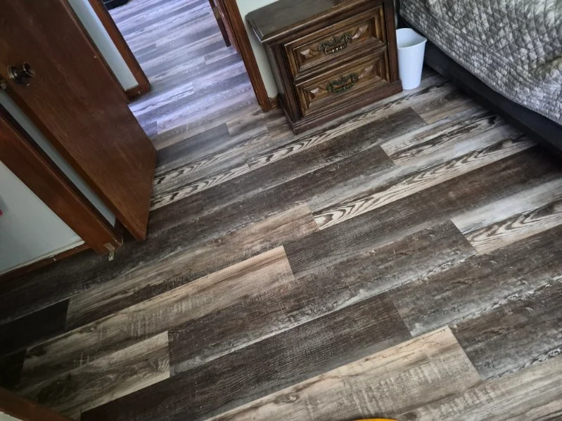 Newly installed luxury vinyl plank flooring with wood-grain texture in bedroom