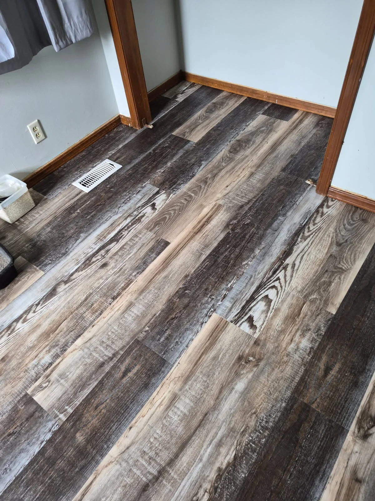 Newly installed luxury vinyl plank flooring with mixed wood tones and realistic grain patterns